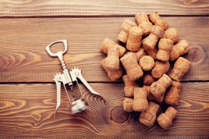 48696061 - wine corks and corkscrew over rustic wooden table background. top view